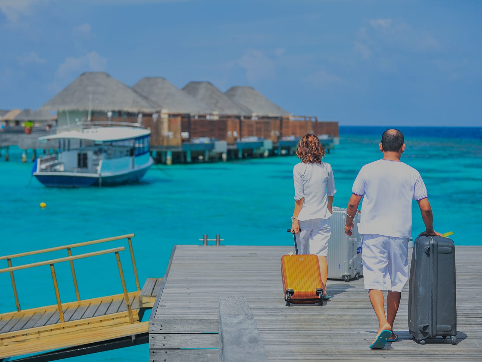 Two vacationers walking on a pier with luggage during travel