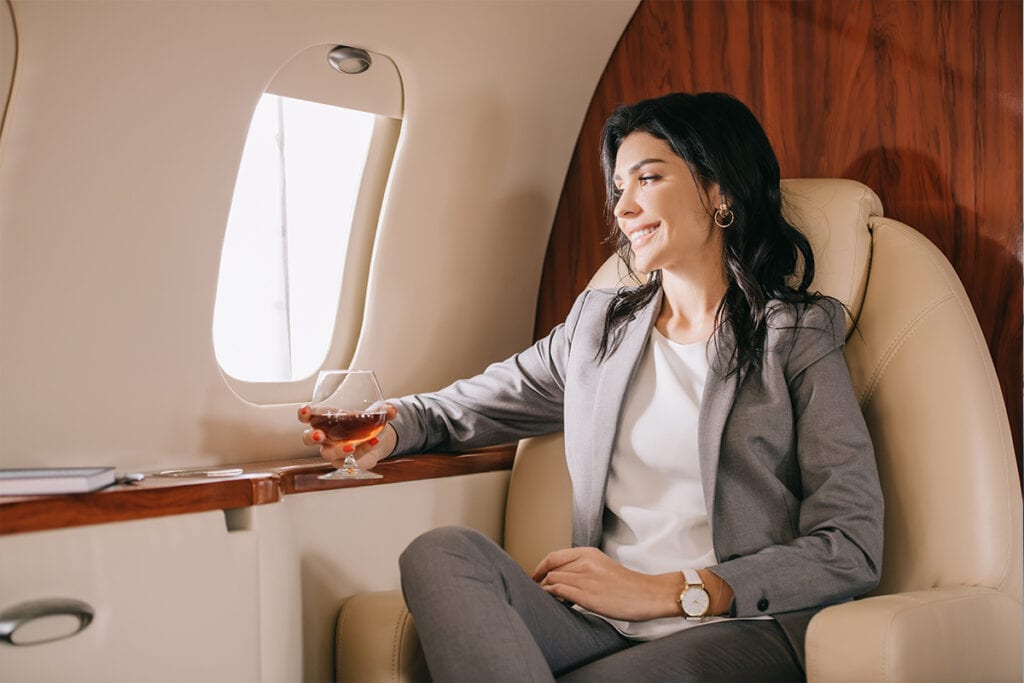 woman drinking cognac and enjoying a private aviation